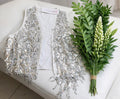 Chaleco blanco y plateado con lentejuelas.