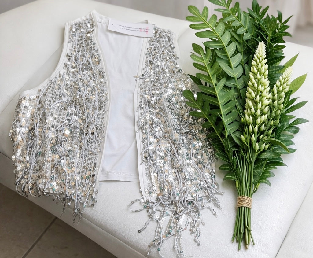 Chaleco blanco y plateado con lentejuelas.